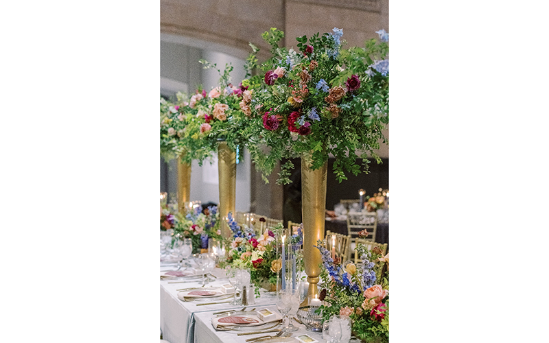 An ornate table arrangement with tall vases filled with flowers