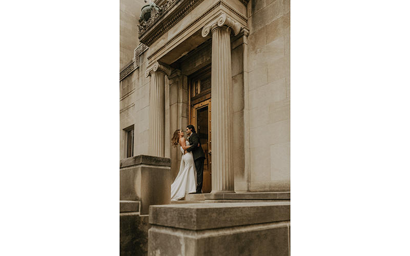 A couple pose on a staircase for a dramatic wedding photo
