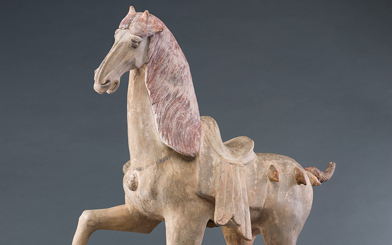 A sculpture of a horse in motion. One front leg is raised