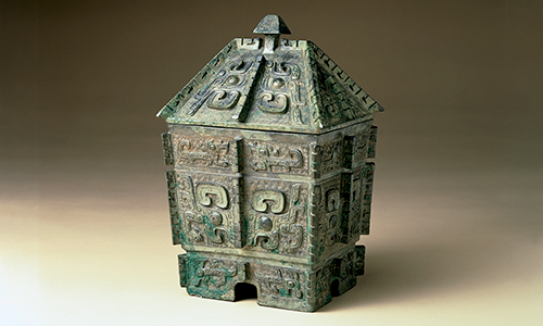 A tarnished, cubic piece with a roof on the top