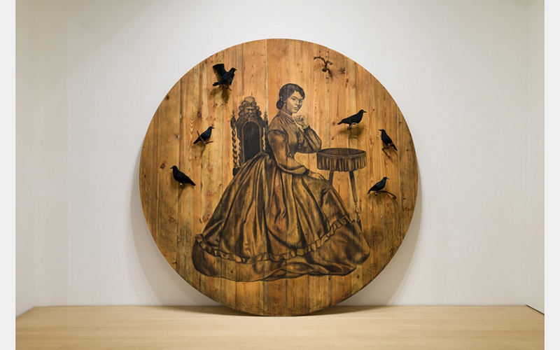 An illustration of a woman in a large dress on a large circle made from wood. Several 3D crows sit on branches sticking out from the wood, arranged around the woman.