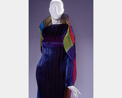 A pleated purple garment with a large multicolored collar and cape