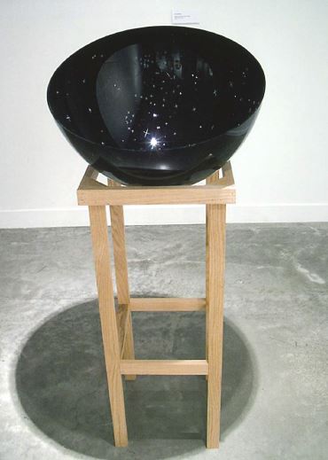 A dark glass bowl that looks like the night sky