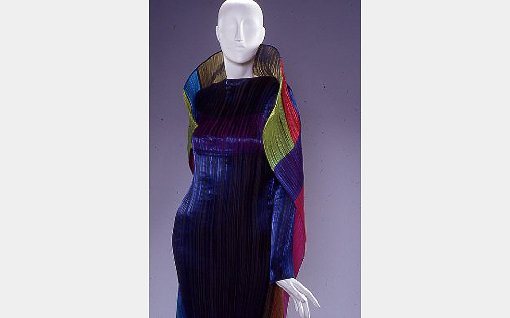 A pleated purple garment with a large multicolored collar and cape