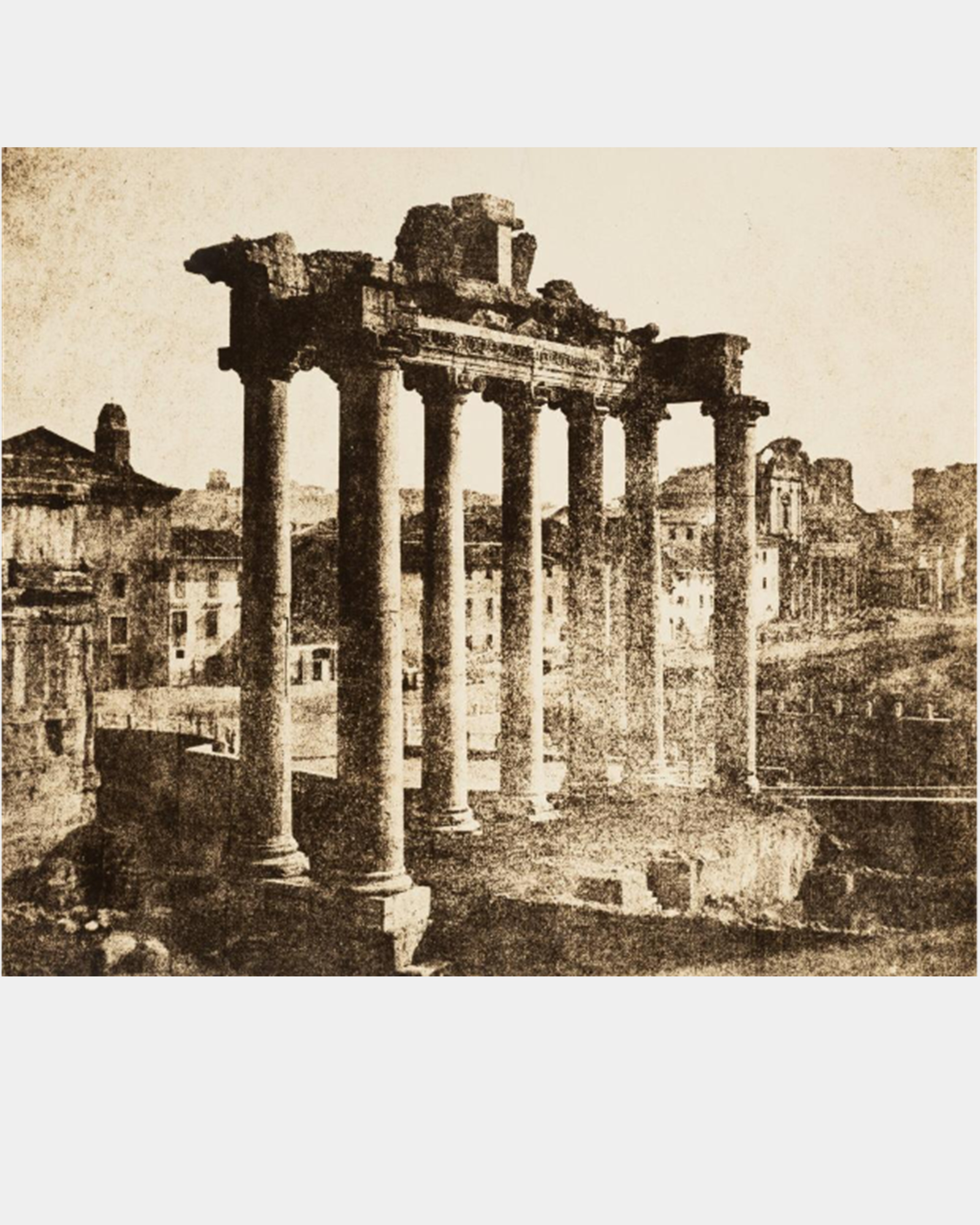 Ruins of a classical era building featuring 7 columns holding up an architrave with buildings in the background
