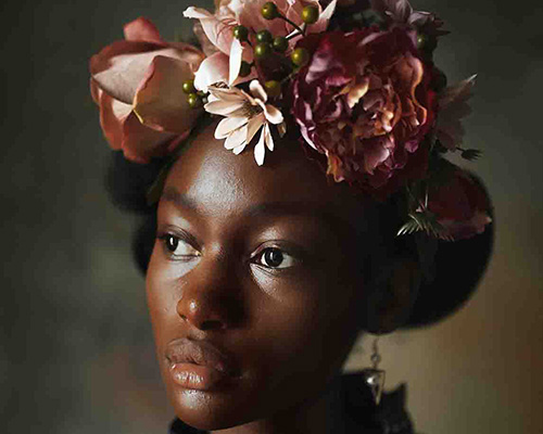 A Black woman wearing a flower crown