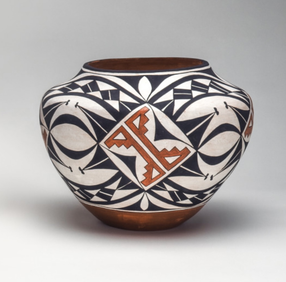 A jar with black and white repeating, geometric shapes