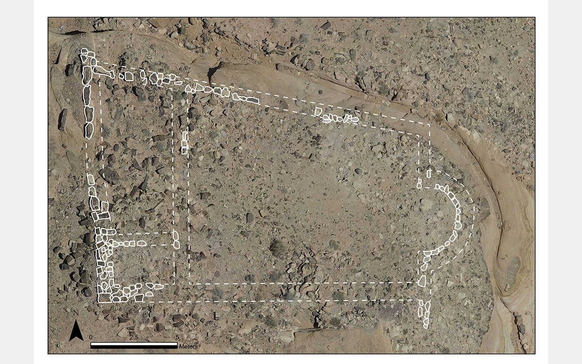 White outlines of a floor plan against an aerial photo of the rocky brown and gray landscape.