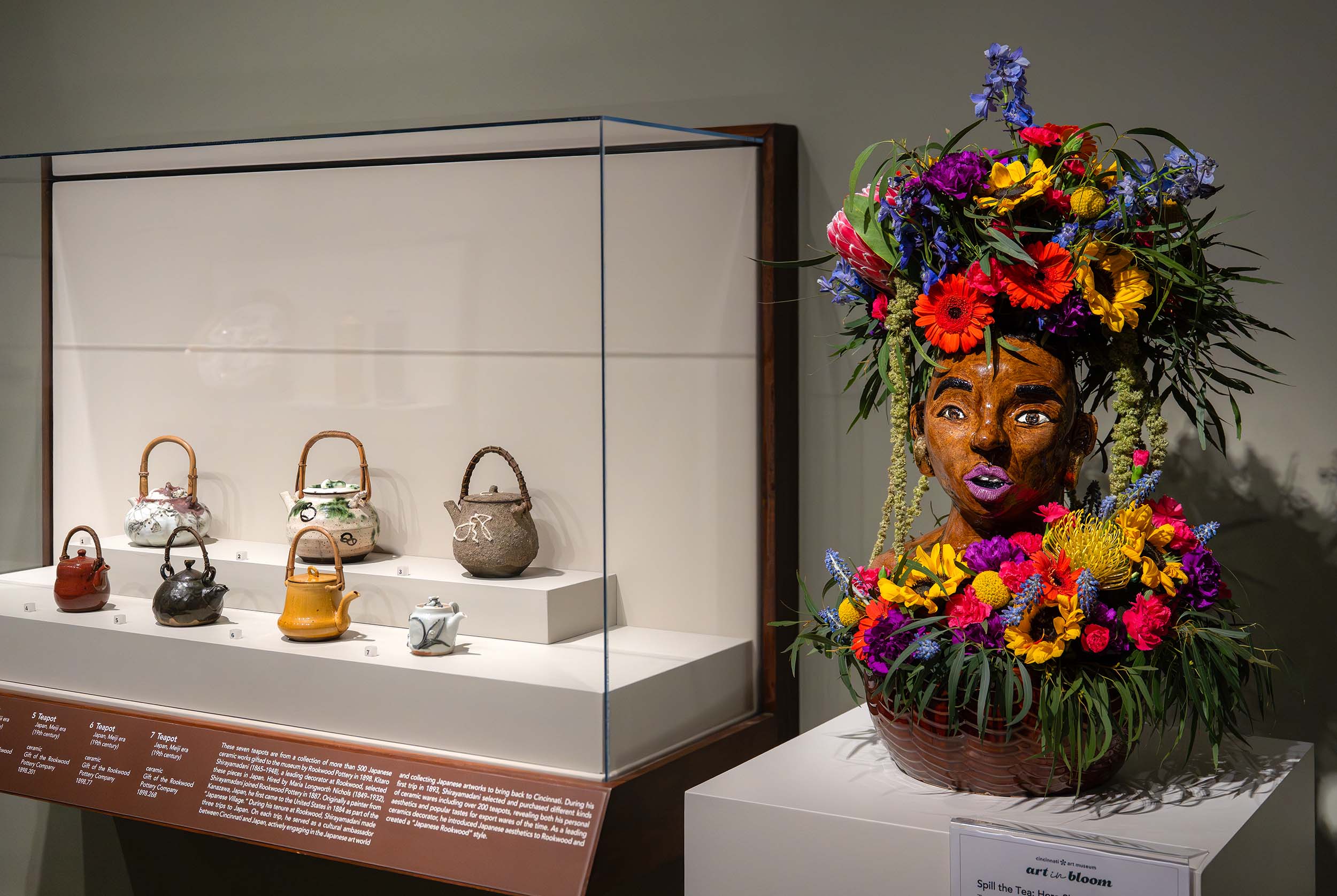 A colorful floral arrangement in a ceramic vase featuring a Black woman's face