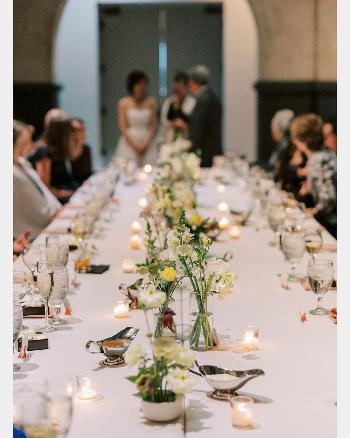 A long table in the museum with floral arrangements and origami paper cranes