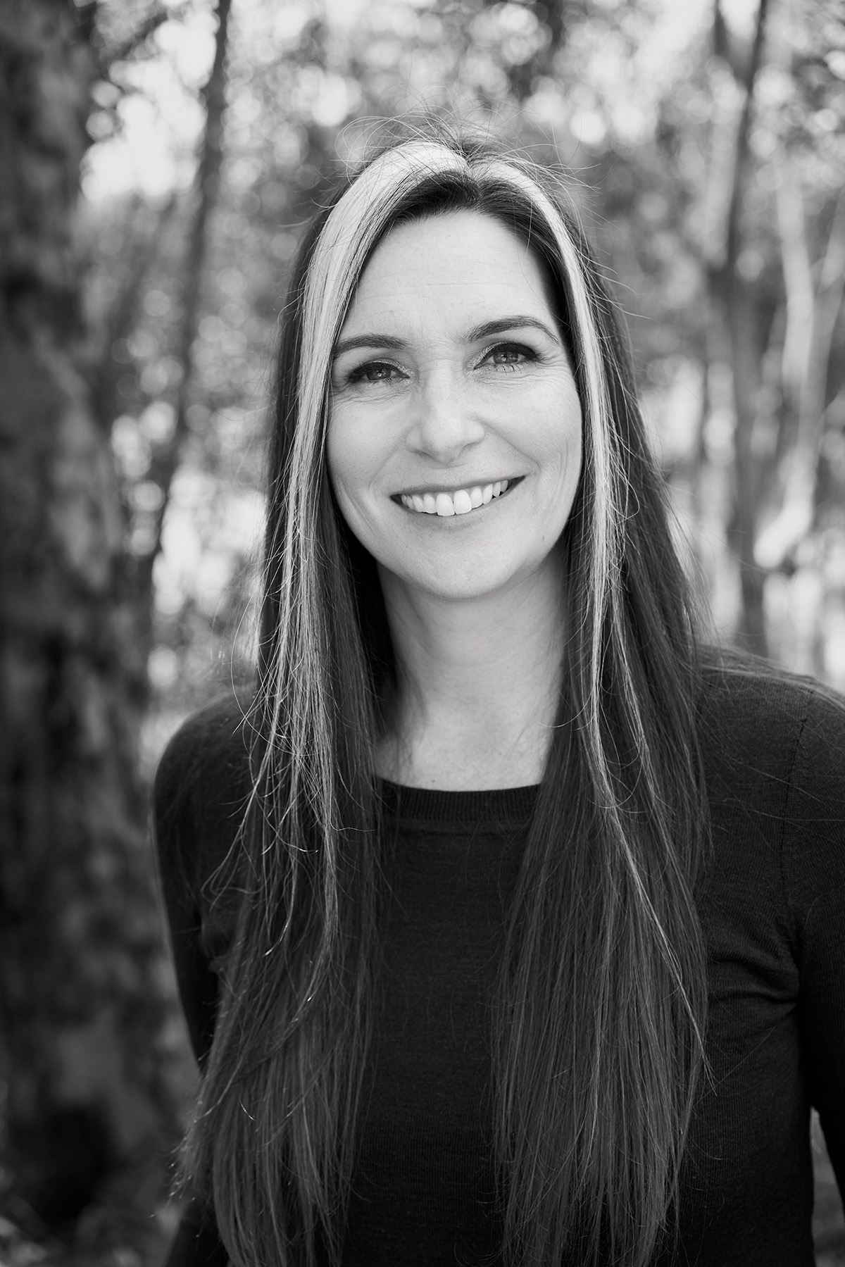 A black and white photo of a smiling white woman