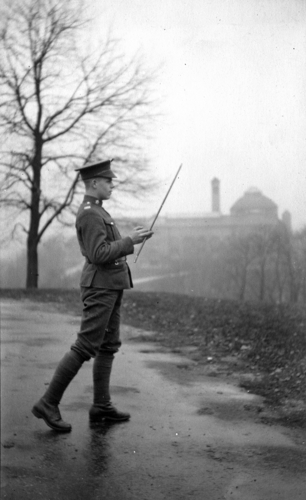 a black and white photograph of a soldier twirling a baton with the Cincinnati Art Museum in the background