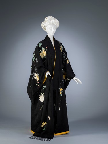 black gown with white and yellow flowers on a mannequin