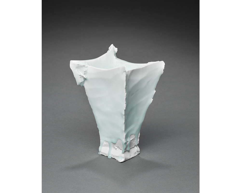 Katō Tsubusa's Vase, a rough textured, tall, square vase that tapers from top to bottom. a faint blue glaze drips down the sides at the base.
