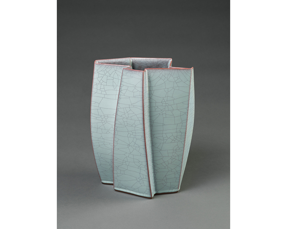 Takagaki Atsushi's Mountain Ridges, a tall vase in a jagged shape glazed in light blue covered in sealed cracks