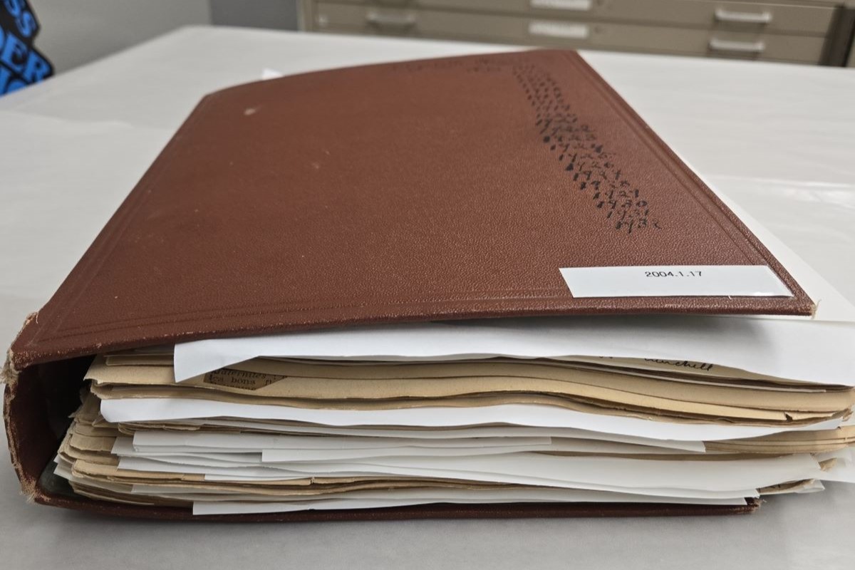 A closed scrapbook bulging with papers