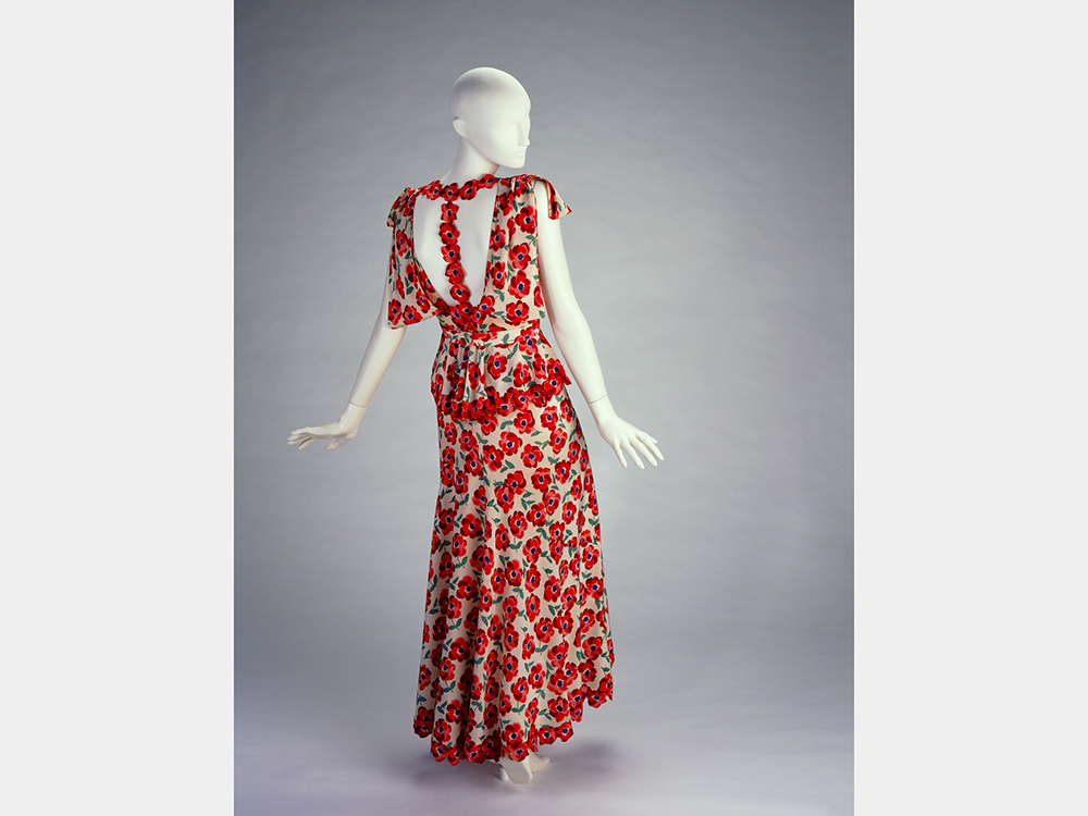 The dress with the red poppies on a mannequin, front and back views.