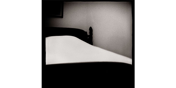 Nancy Rexroth's A Woman's Bed, a black and white photograph of a simple bed