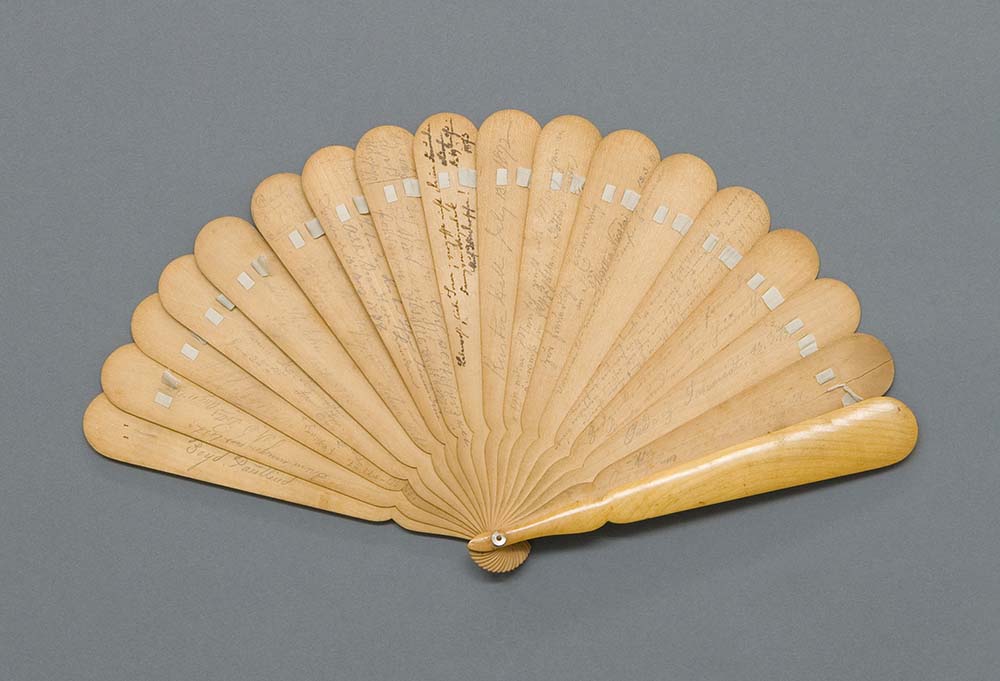 wooden hand fan with faint writing