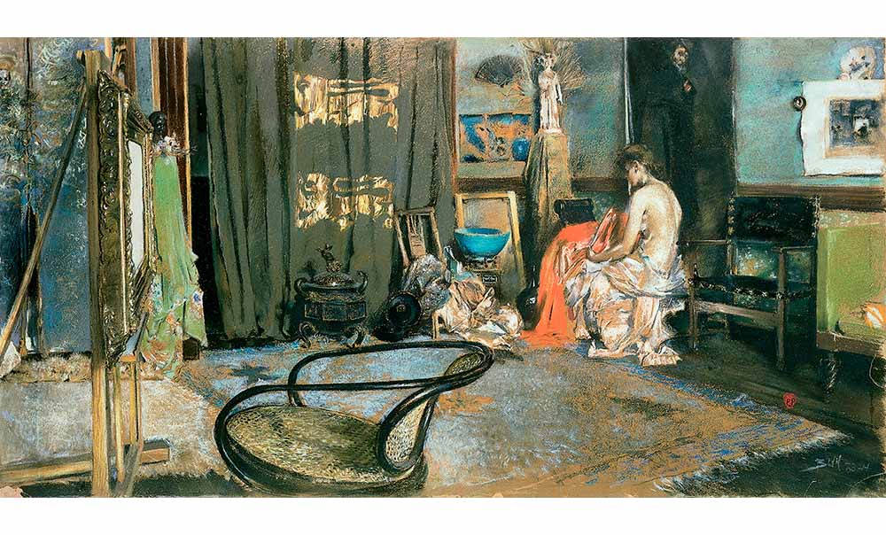 Robert Frederick Blum's Studio of Robert F. Blum, a rectangular painting of a nude woman with a sheet wrapped around her waist sitting in the corner of a large studio with an area rug in the middle. Various paintings and chairs line the wall. In the foreground is a chair and an ornate frame mounted on an easel.