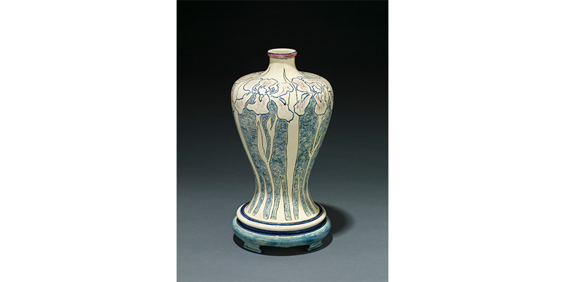 Mary Sheerer's Newcomb Pottery, an ornamental vase with a small neck, and wide shoulder that tapers downward then flares out at the bottom, decorated in a floral design