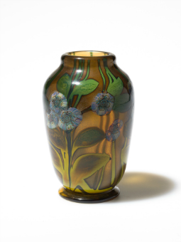 brown, glass vase with blue flowers and green leaves