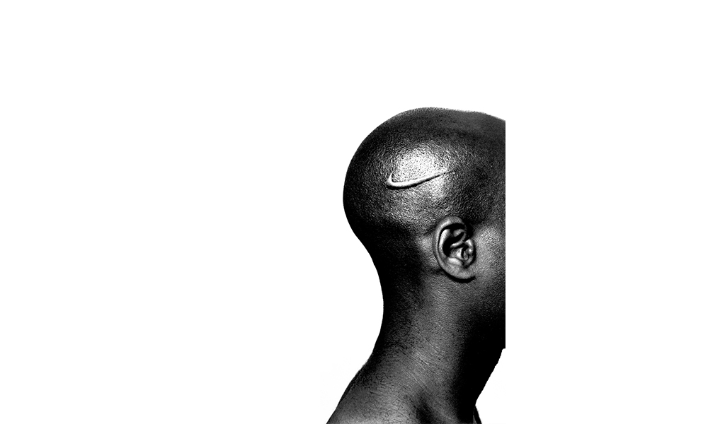 Hank Willis Thomas' Branded Head, the head of an African American man branded with the Nike swoosh on the side. The man is facing towards the right but his face is abruptly cut off 
