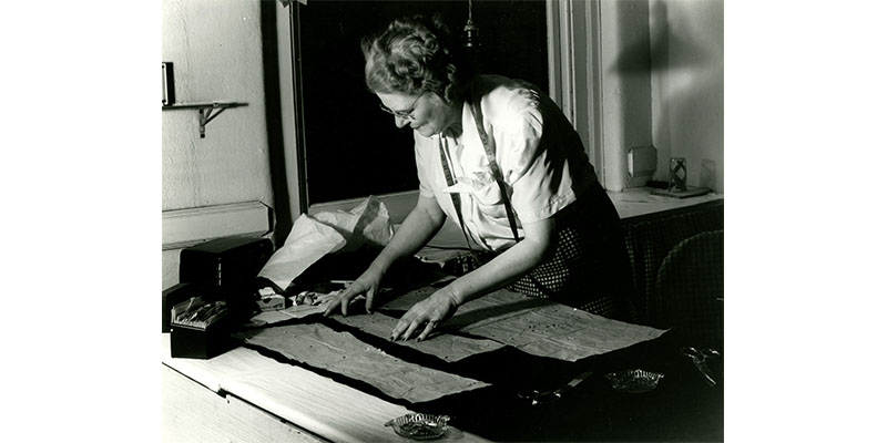 black and white photo of a woman working at a desk