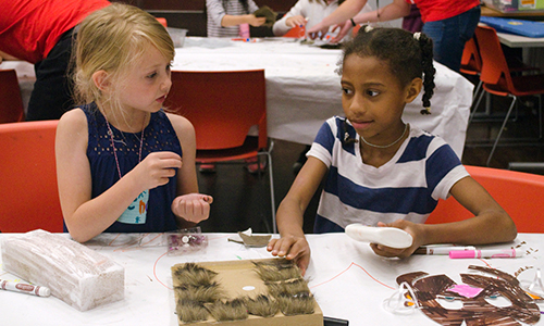 two youth visitors participating in arts and crafts