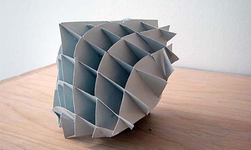 large paper sculpture with a round bottom and pointed top, divided into a grid of squares