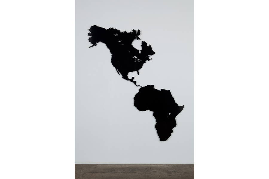 Hank Willis Thomas' A Place to Call Home (Africa-America) black, aluminum map of North America and Africa. Africa in place of where normally South America would be