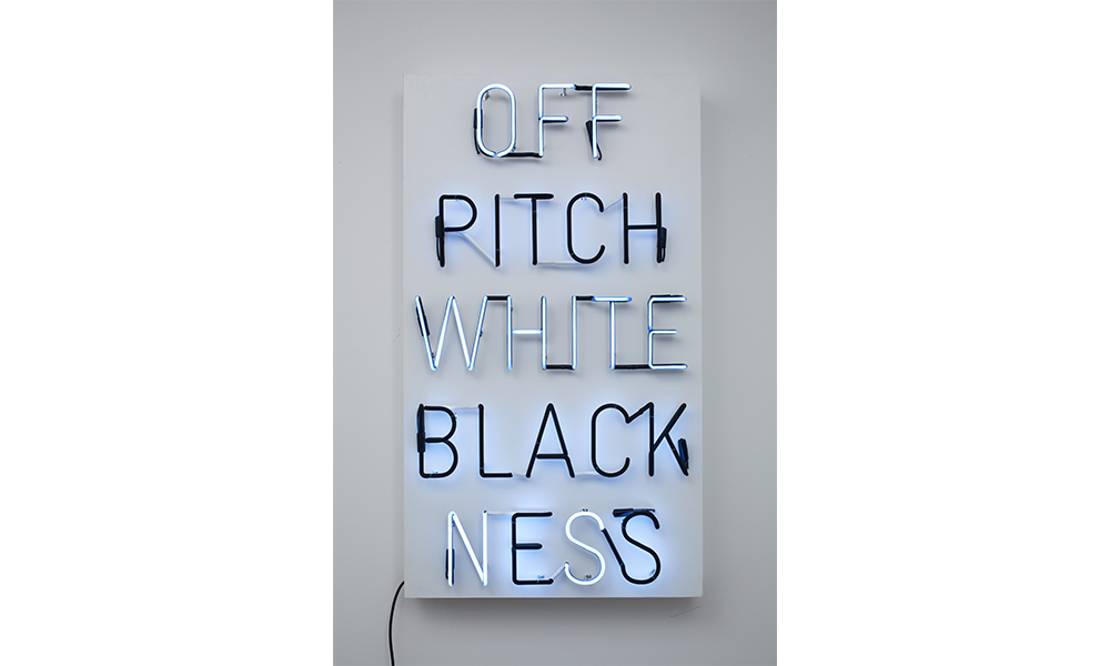 Hank Willis Thomas' Pitch Blackness/Off White, a neon sign that reads top to bottom: Off pitch white blackness