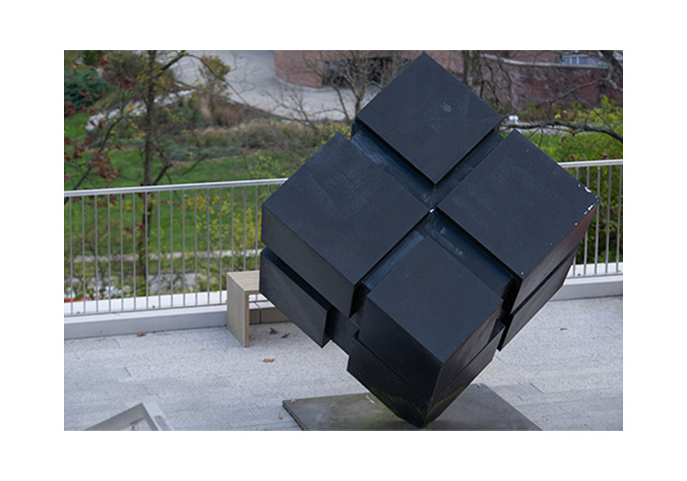 statue of a black cube comprised of smaller cubes