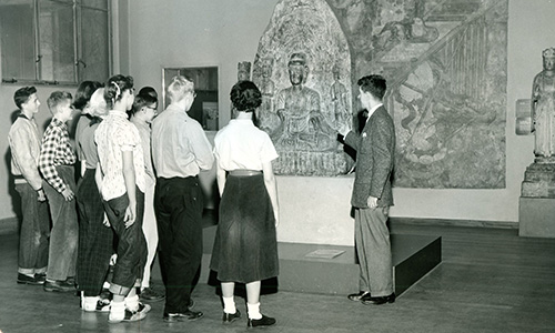 A historic, black-and-white photo of a guided tour