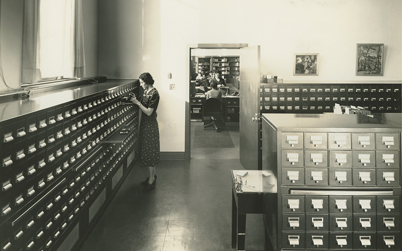 A vintage black-and-white photo of students exploring the museum's card catalog