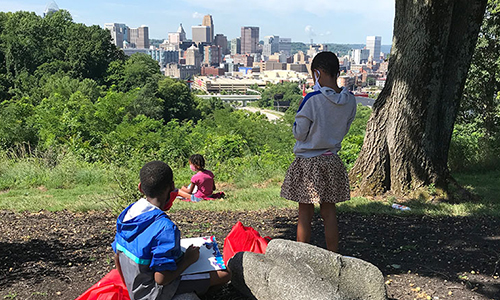 Students sketch the downtown Cincinnati skyline from the museum hillside