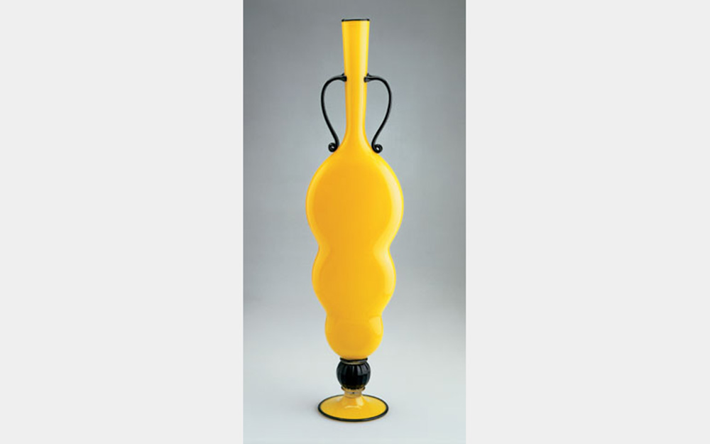 A tall, thin yellow vase with simple black details