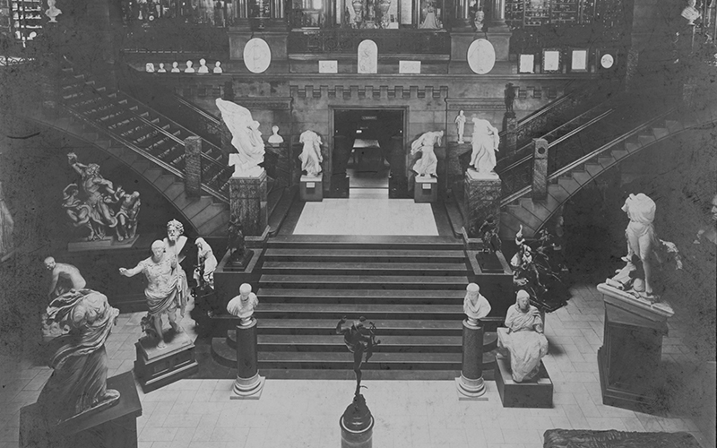 A historic black and white photo of the Great Hall, filled with statues of people