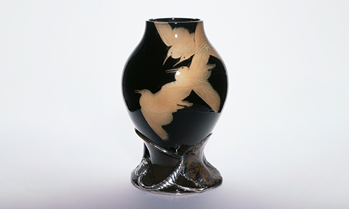 Dark, shiny vase with flying bird figures