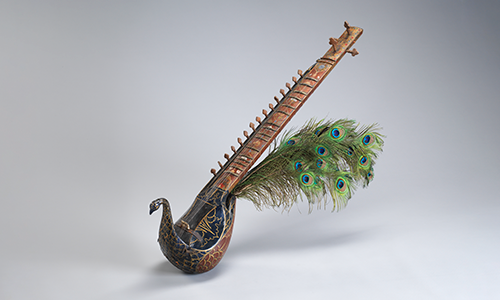 wooden sitar with peacock feathers