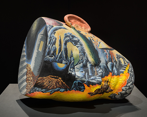 A head-shaped vessel with a colorful landscape painting on the surface