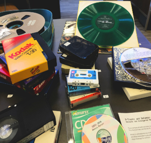a collection of film, casette tapes, CDs, and other media