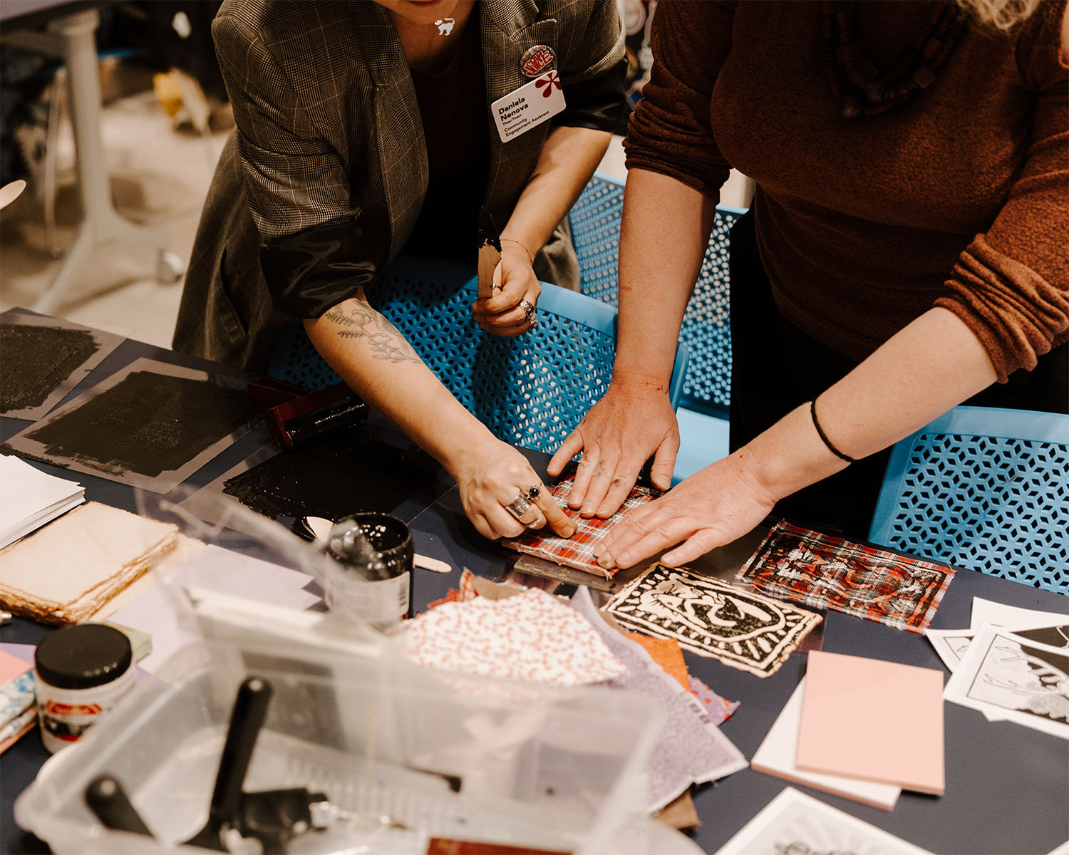 A facilitator assists an adult with a craft project