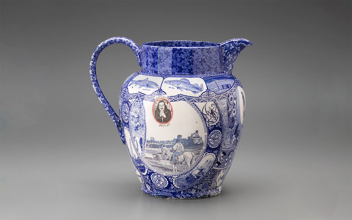 A large pitcher with blue image transfer