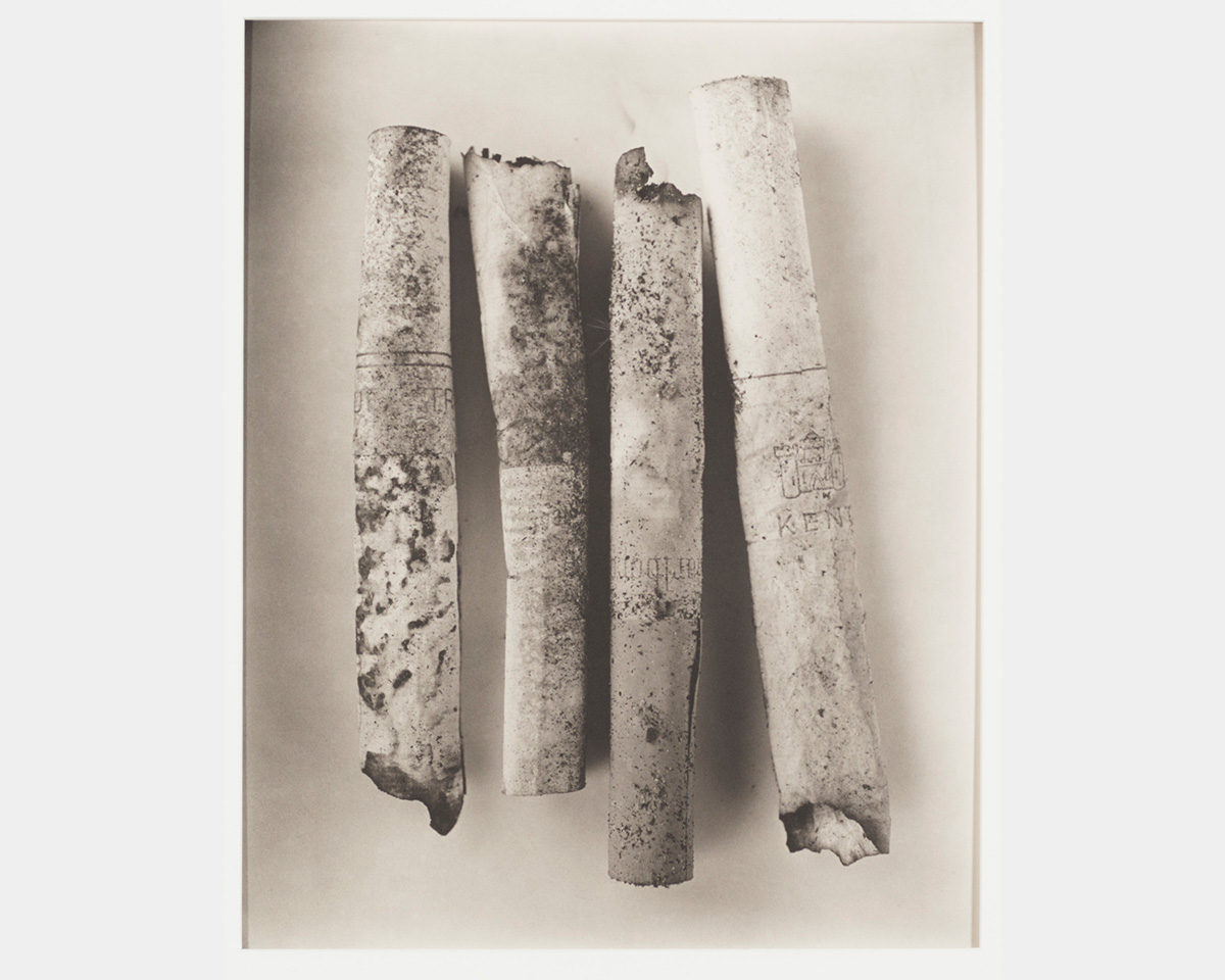 A black and white photo of four smoked cigarettes