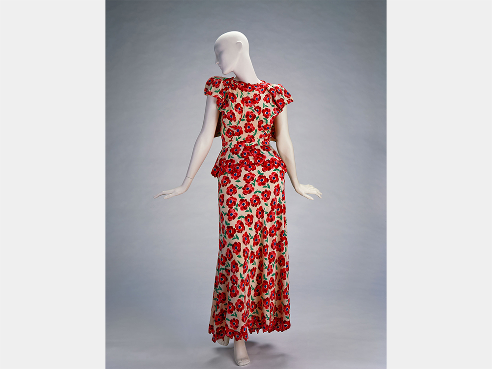 The dress with the red poppies on a mannequin, front and back views.