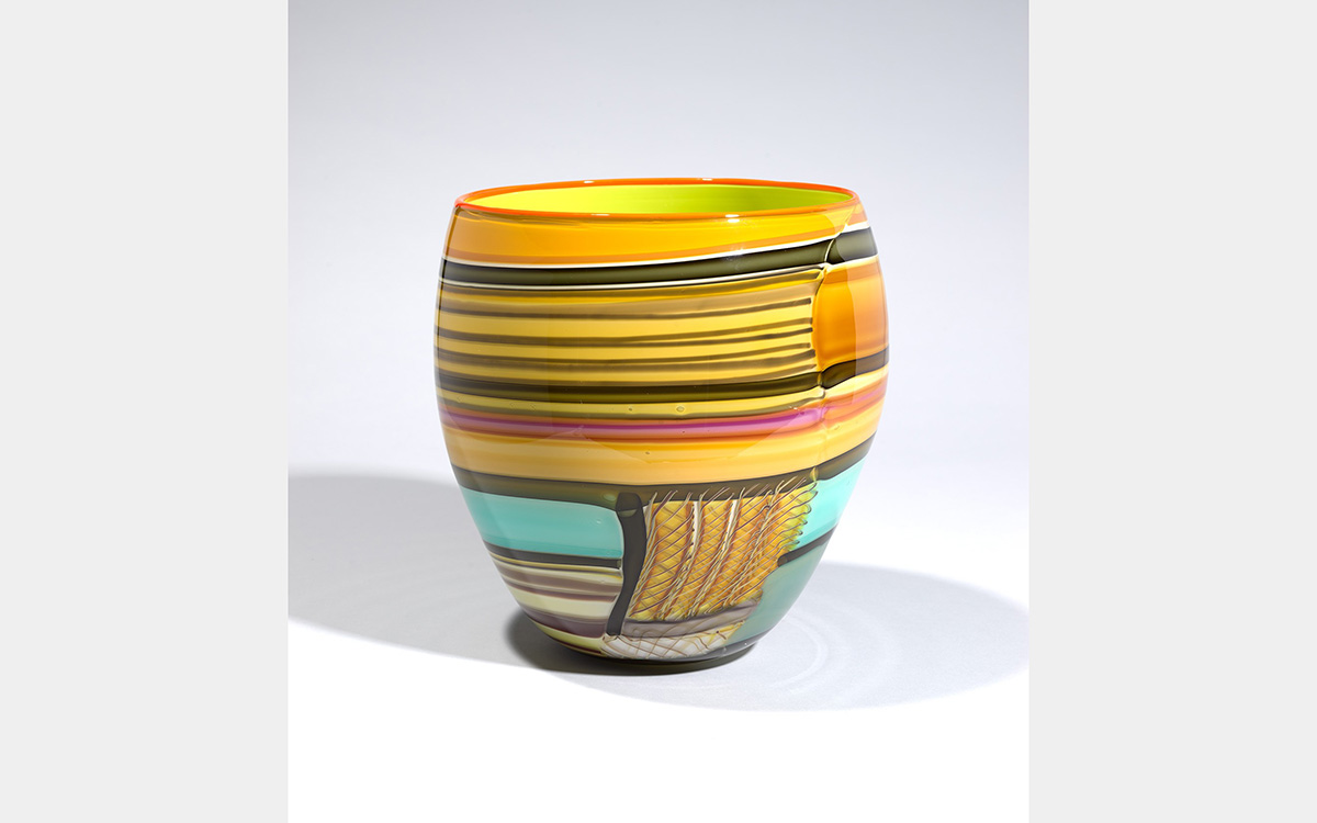 Brightly colored vase with tones of yellow, orange, pink, green with black striations.