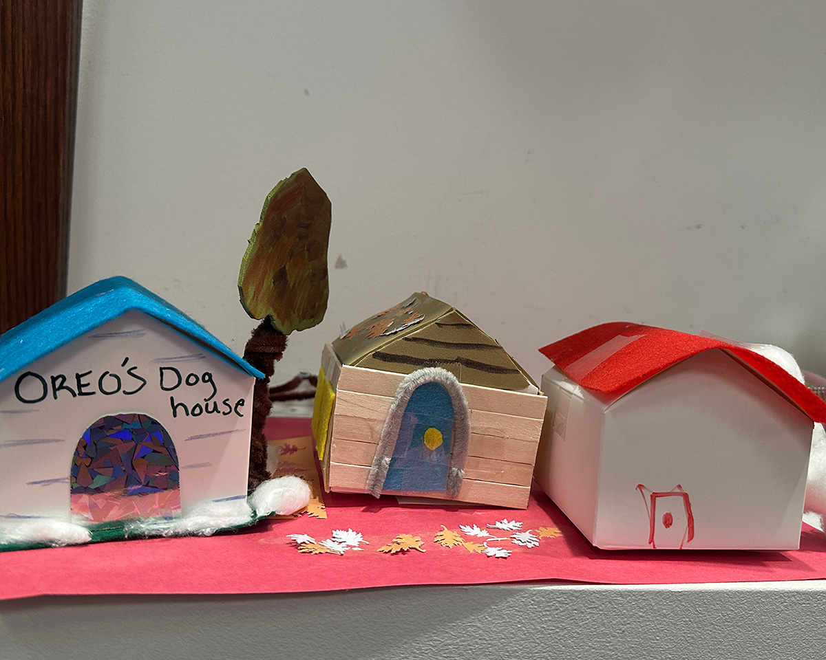 Three toy houses made of paper and assorted colorful materials