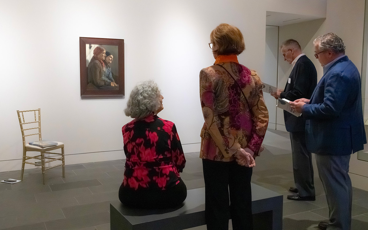 Three Founders and a curator discuss a painting in a gallery
