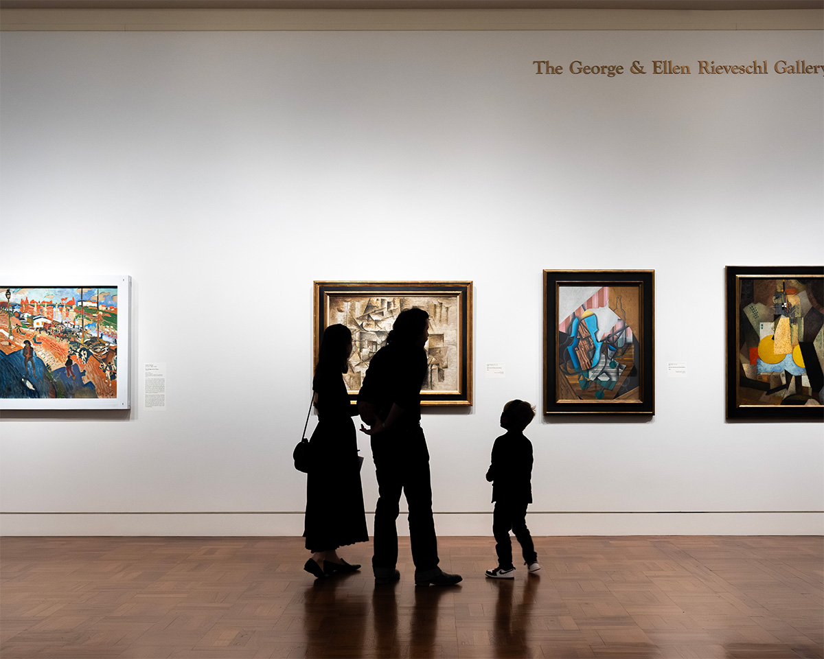 A family looks at artworks in a gallery